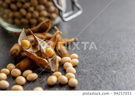 Soy beans. Dried soybean pod on black table. 94257851