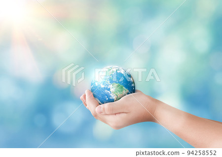 Hands holding global on blurred nature background Hands holding global on blurred nature background 94258552