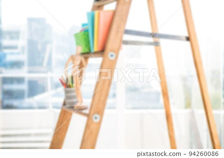 Files and wooden figurine on step ladder 94260086