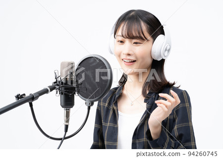 Young woman singing with white headphones 94260745