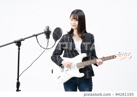 年輕女子一邊彈電吉他一邊唱歌 94261195