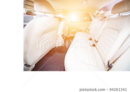 Car interior luxury. Beige comfortable seats, steering wheel, dashboard, climate control, speedometer, display, wood decoration light Car interior luxury. Beige comfortable seats, steering wheel, dashboard, climate control, speedometer, display, wood decoration light 94261341