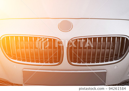 Predatory car headlight with blue lights and hood of powerful grey blue car sports car with matte grey paint and wheel with blue disc Predatory car headlight with blue lights and hood of powerful grey blue car sports car with matte grey paint and wheel with blue disc 94261584