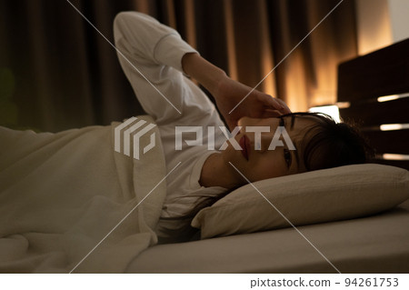 一個無法入睡的女人在床上感到頭痛和失眠 94261753