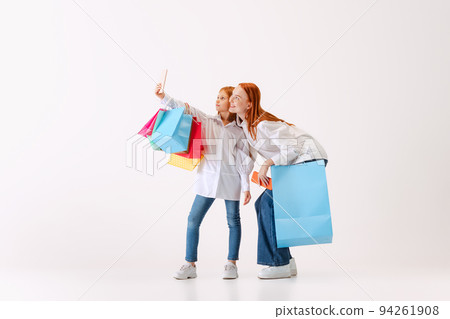 Beautiful young redhaired woman and little girl going shopping with shopping bags isolated on white background, Concept of black Friday, cyber Monday, sales Beautiful young redhaired woman and little girl going shopping with shopping bags isolated on white background, Concept of black Friday, cyber Monday, sales 94261908