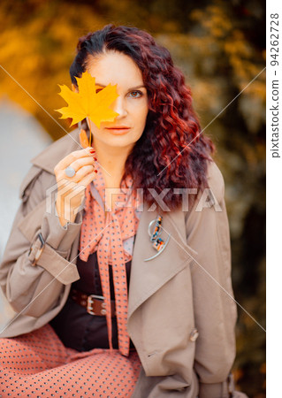 Beautiful girl walking outdoors in autumn. Smiling girl collects yellow leaves in autumn. Young woman enjoying autumn weather. Beautiful girl walking outdoors in autumn. Smiling girl collects yellow leaves in autumn. Young woman enjoying autumn weather. 94262728