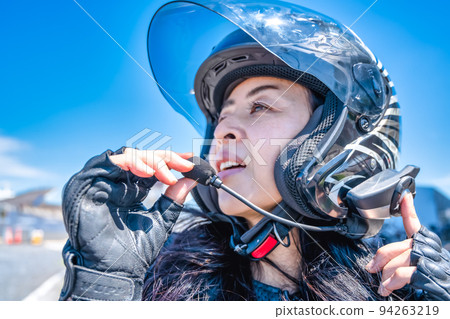 A female rider touring Yokohama on a large cruiser bike Conversation at the intercom 94263219