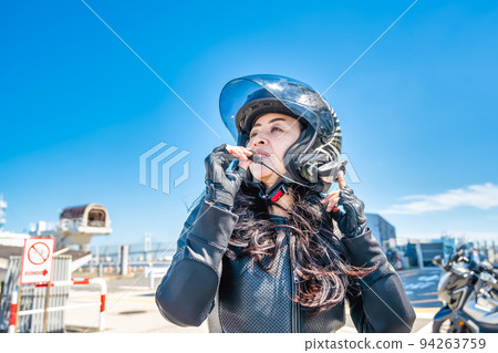 一位騎著大型巡洋艦自行車遊覽橫濱的女騎手在對講機上的對話 一位騎著大型巡洋艦自行車遊覽橫濱的女騎手在對講機上的對話 94263759