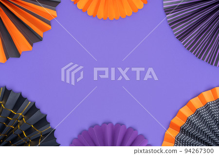 Halloween background. Bright paper fans are laid out in the form of a frame on a purple background. 94267300