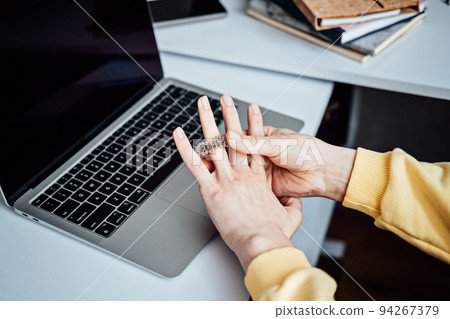 Acupuncture Su Jok, sujok, su jok, su-jok is traditional Chinese medicine therapy. Sujok Pain Therapy Finger Massager Circulation Rings on female hands near laptop on workplace 94267379