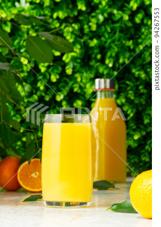 Glass of orange juice and orange juice bottle. Fresh tropical juice. Glass of orange juice and orange juice bottle. Fresh tropical juice. 94267553