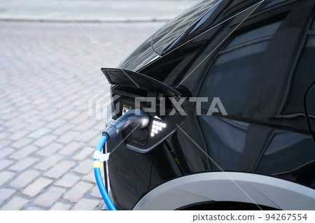 Electromobile charging plug is inserted into vehicle charging socket. Electromobile charging plug is inserted into vehicle charging socket. 94267554