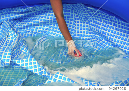 Cleaning pvc inflatable swimming pool, Cleaning the dirty empty pool of algae 94267928