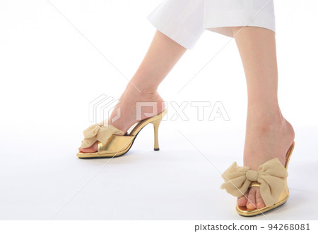 feet wearing gold sandals 94268081