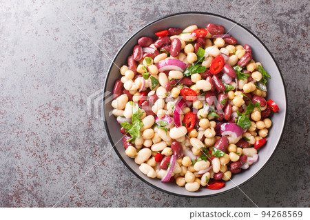 Vegetarian salad of three beans close-up in a bowl. Horizontal top view 94268569