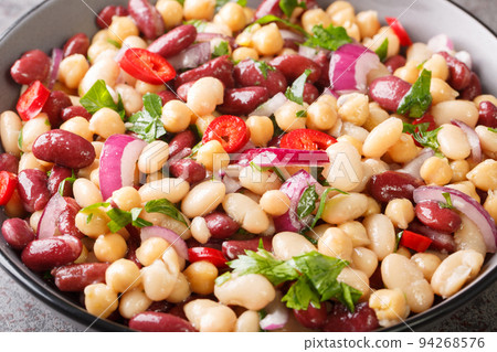 Delicious vegetable salad three beans with chili peppers and red onions close-up in a bowl. Horizontal Delicious vegetable salad three beans with chili peppers and red onions close-up in a bowl. Horizontal 94268576
