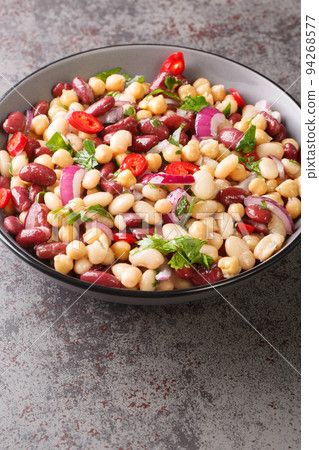 Three bean salad with chickpeas, onions, chili peppers and olive oil dressing close-up in a bowl. Vertical Three bean salad with chickpeas, onions, chili peppers and olive oil dressing close-up in a bowl. Vertical 94268577