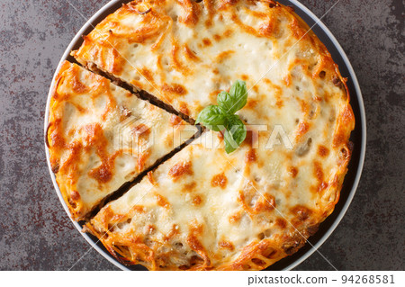 Spicy hot pie spaghetti casserole with ground beef, tomato sauce and parmesan cheese and mozzarella close-up in a plate. horizontal top view Spicy hot pie spaghetti casserole with ground beef, tomato sauce and parmesan cheese and mozzarella close-up in a plate. horizontal top view 94268581
