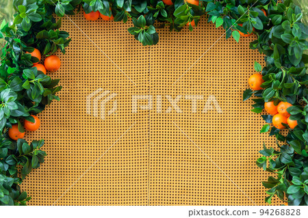 Border made of orange trees. Oranges hanging on branches making a frame in the garden with space for text. 94268828