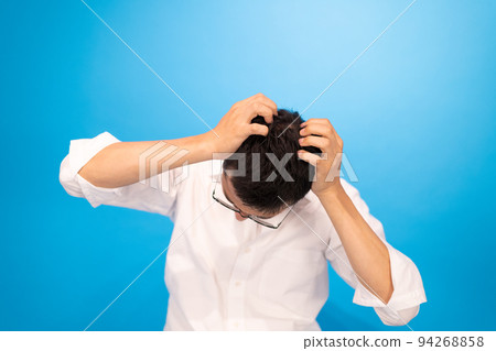 A man holding his head and lamenting his failure A man holding his head and lamenting his failure 94268858