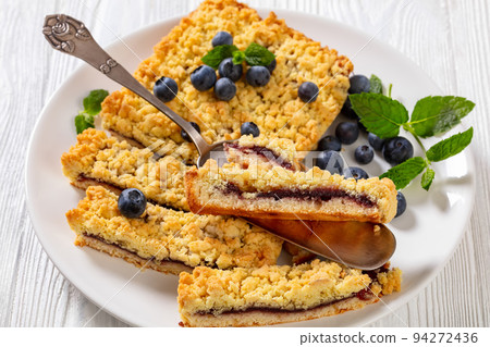 sliced blueberry crumble pie on plate, top view 94272436