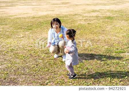 幼兒園和幼兒園老師在公園草坪廣場玩耍 94272921