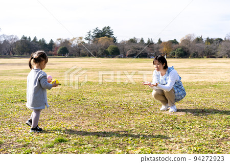 Kindergarteners and nursery teachers playing on the lawn square in the park 94272923