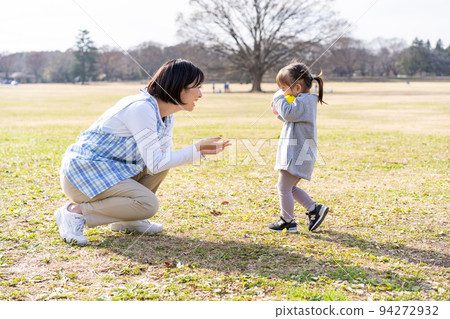 Kindergarteners and nursery teachers playing on the lawn square in the park 94272932