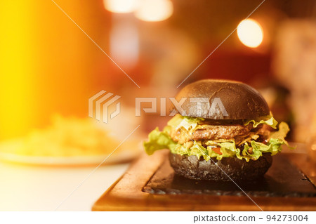 Closeup Of Juicy Burger With Tasty Cutlet And Lettuce Between Soft Roasted Buns In Restaurant. Front View Burger With Veggies And Meat. Juicy Hamburger. Copy Space 94273004