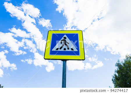 Blue and white pedestrian crossing sign on the sky background Blue and white pedestrian crossing sign on the sky background 94274417