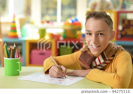Boy draws at the table in the room Boy draws at the table in the room 94275518