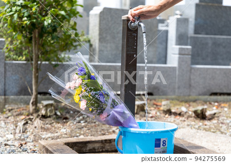 一位來掃墓的老人正在往桶裡倒水 94275569