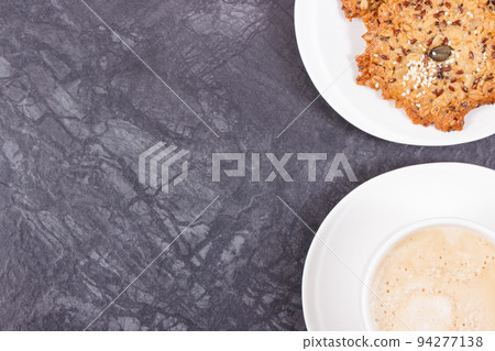 Cup of coffee with milk and fresh baked healthy oatmeal cookies. Delicious crunchy dessert 94277138