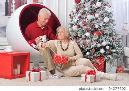 Elderly couple in a room with New Year's decor Elderly couple in a room with New Year's decor 94277302