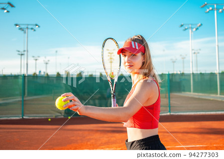 beautiful young woman plays tennis on the court. Serves the ball, sports team game. Active lifestyle, outdoor recreation, body fitness. nice weight loss. The girl smiles, happy. Portrait of an athlete beautiful young woman plays tennis on the court. Serves the ball, sports team game. Active lifestyle, outdoor recreation, body fitness. nice weight loss. The girl smiles, happy. Portrait of an athlete 94277303