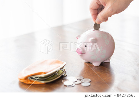 將 100 日元硬幣放入存錢罐的男人 94278563