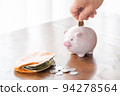 A man who puts a 10-yen coin in a piggy bank 94278564