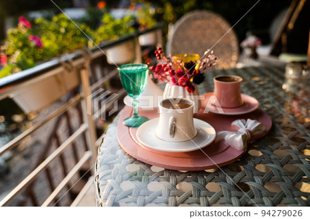 Turkish coffee cups served outside with water flowers and delight dessert in romantic setup on glass table 94279026