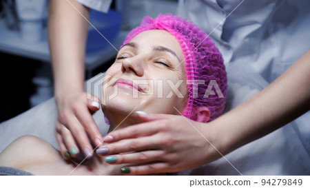 Attractive female at spa health club getting a facial massage. Beautician doing massage of face, neck and shoulders ofbeautiful young woman at luxury beauty salon 94279849