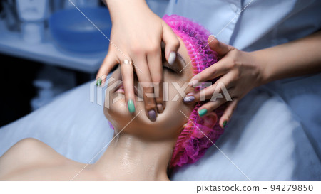 Attractive female at spa health club getting a facial massage. Beautician doing massage of face, neck and shoulders ofbeautiful young woman at luxury beauty salon 94279850