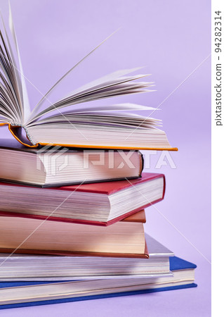 Close-up of a stack of books with one open book on top 94282314