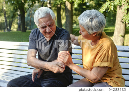 Elderly man got injured his elbow during stroll with wife in park Elderly man got injured his elbow during stroll with wife in park 94282383