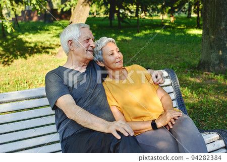 Elderly couple resting sit on bench in summer park 94282384