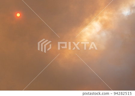 Cloud of smoke from large forest fire passing in front of sun. Cloud of smoke from large forest fire passing in front of sun. 94282515