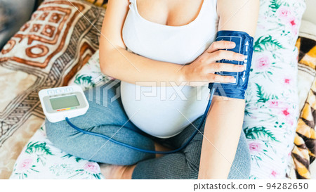Pregnant blood pressure check hypertension. Pregnancy mother with blood test hypertension check pressure. Concept of pregnancy, maternity, expectation for baby birth. 94282650