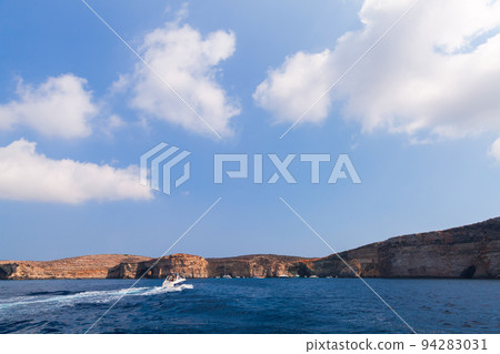 Pleasure boat sails near coastal caves of the Blue Lagoon 94283031