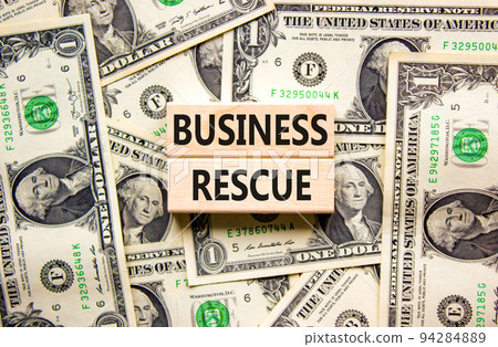 Business rescue symbol. Concept words Business rescue on wooden blocks on a beautiful background from dollar bills. Business rescue and support concept. Copy space. Business rescue symbol. Concept words Business rescue on wooden blocks on a beautiful background from dollar bills. Business rescue and support concept. Copy space. 94284889