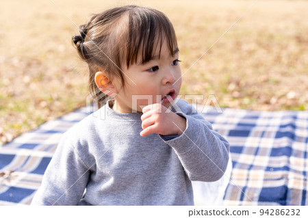 Girl eating ice cream at picnic 94286232