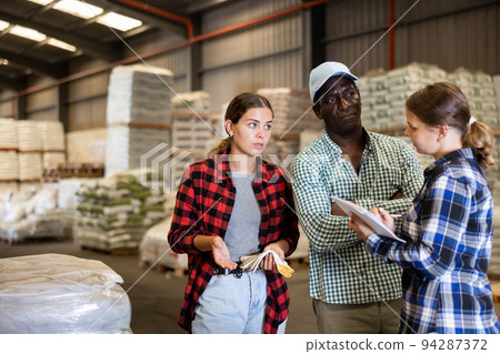 Man and women working in warehouse, discussing job 94287372
