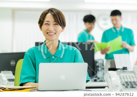 A young woman working in a polo shirt uniform 94287612